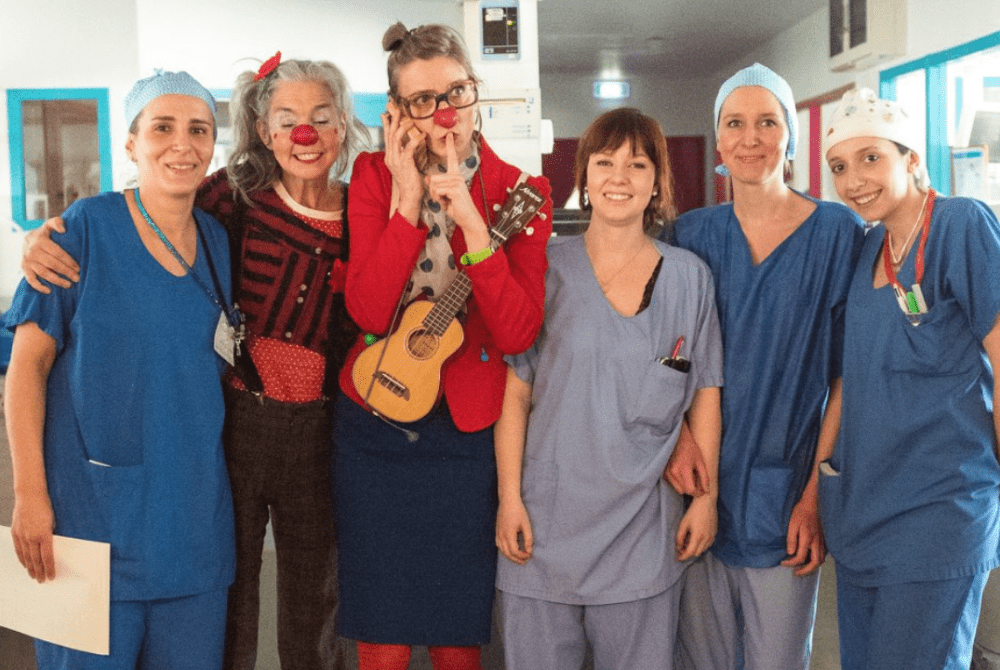 deux clowns posant avec une équipe soignante